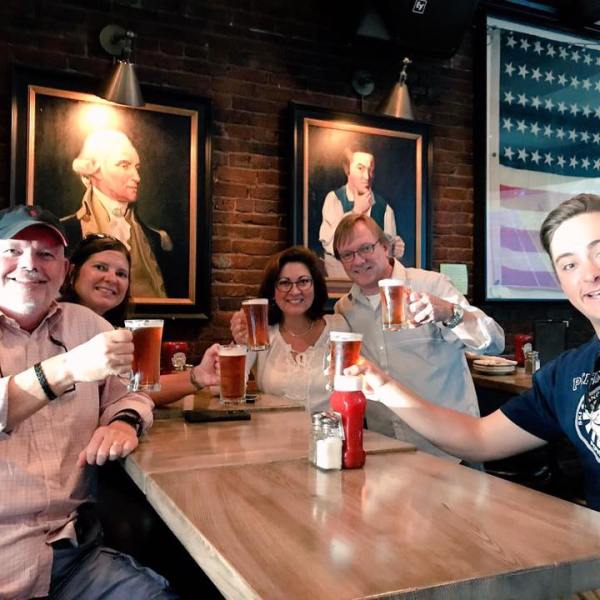 a group of people sitting at a table with beers