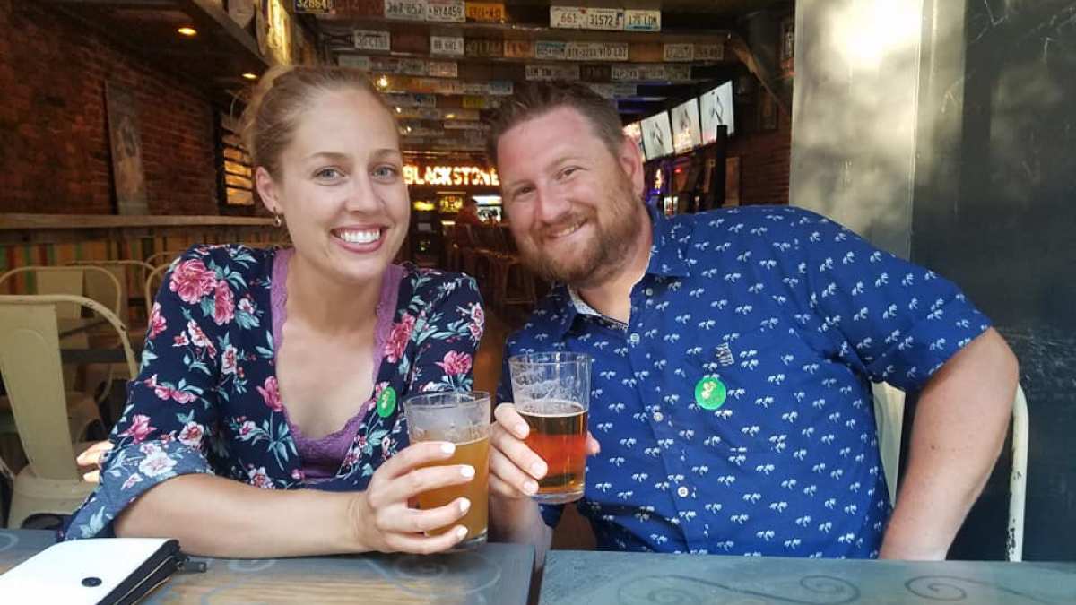a couple sitting at a table with beers